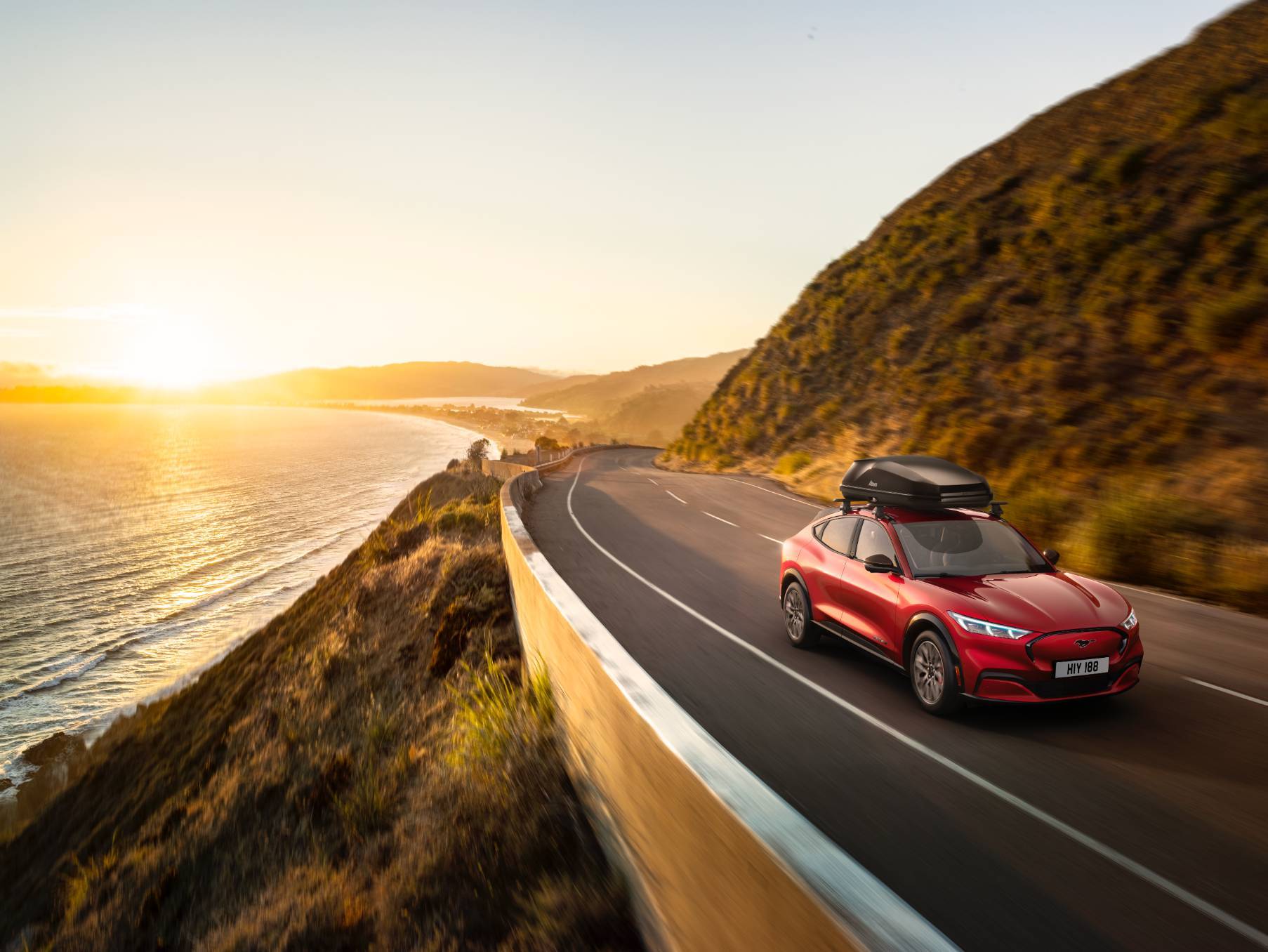 A Ford Mach-E driving on a coastal highway.